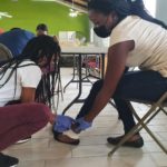 Female wrapping another female's ankle. 