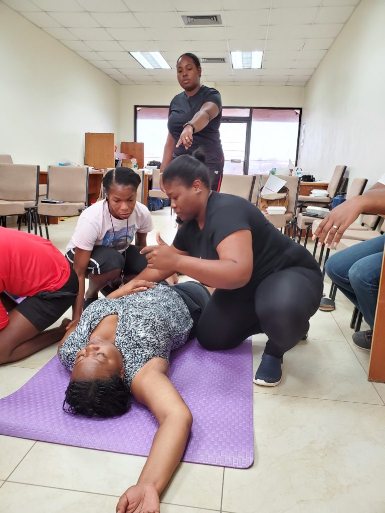 Training, someone on the ground and four persons helping her